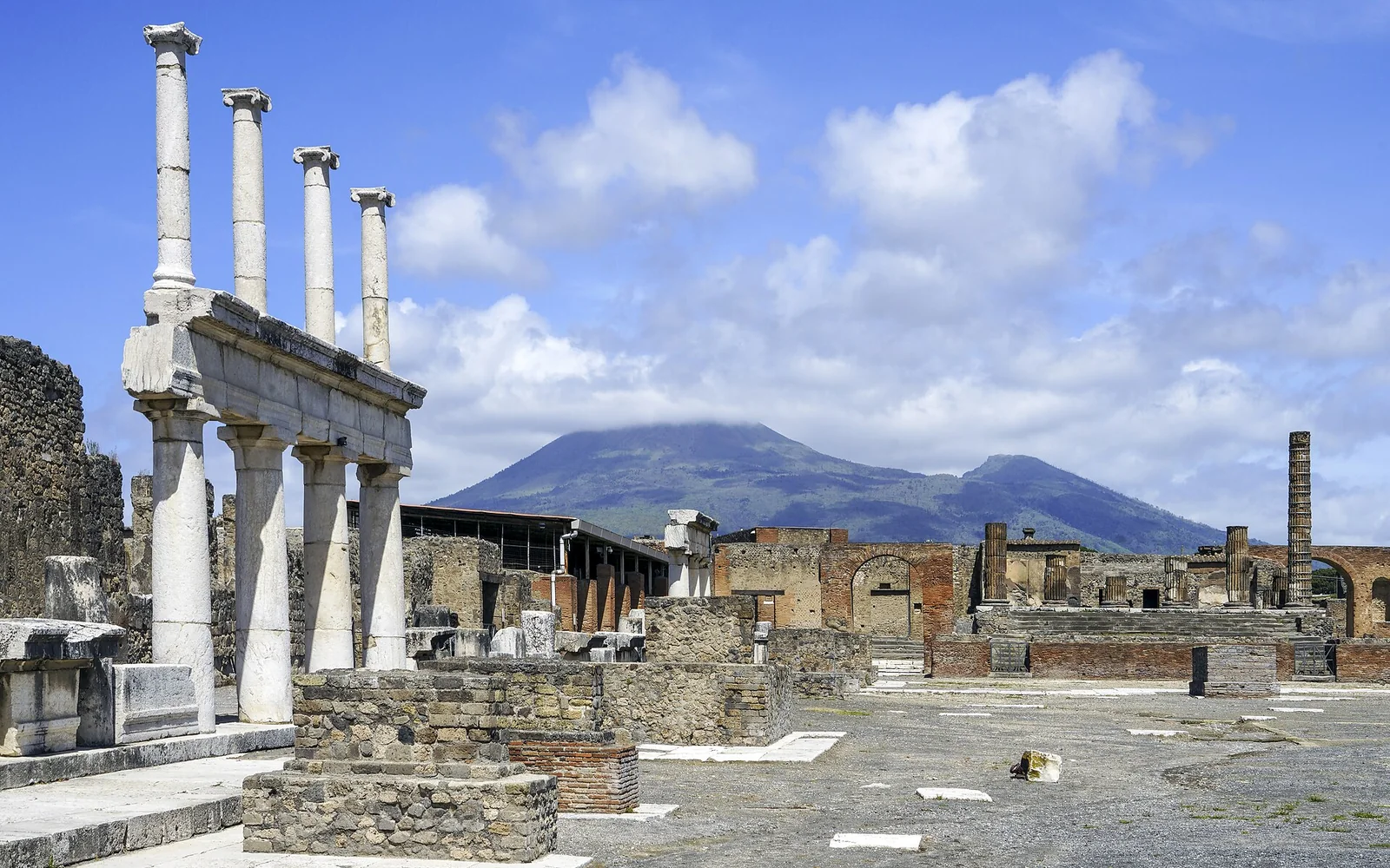 The Forum of Pompeii with ancient columns and Mount Vesuvius beyond